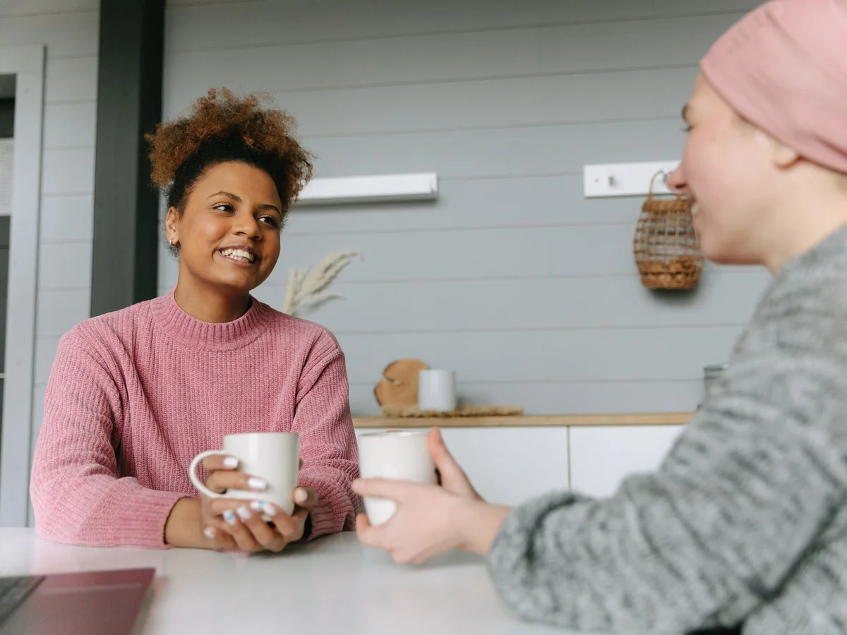 Two women having an honest conversation over tea